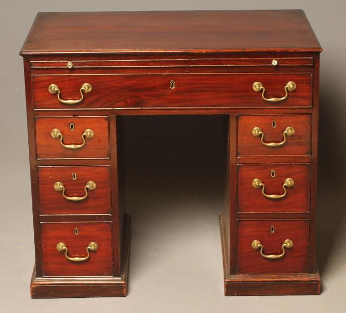 A SMALL MAHOGANY KNEEHOLE DESK Image