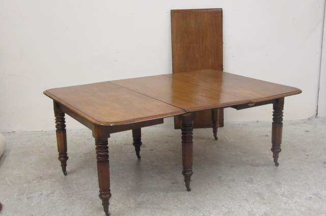 A VICTORIAN MAHOGANY EXTENDING DINING TABLE of rounded oblong form with pull out action and two Image
