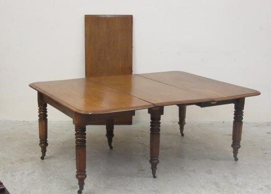 A VICTORIAN MAHOGANY EXTENDING DINING TABLE of rounded oblong form with pull out action and two Image