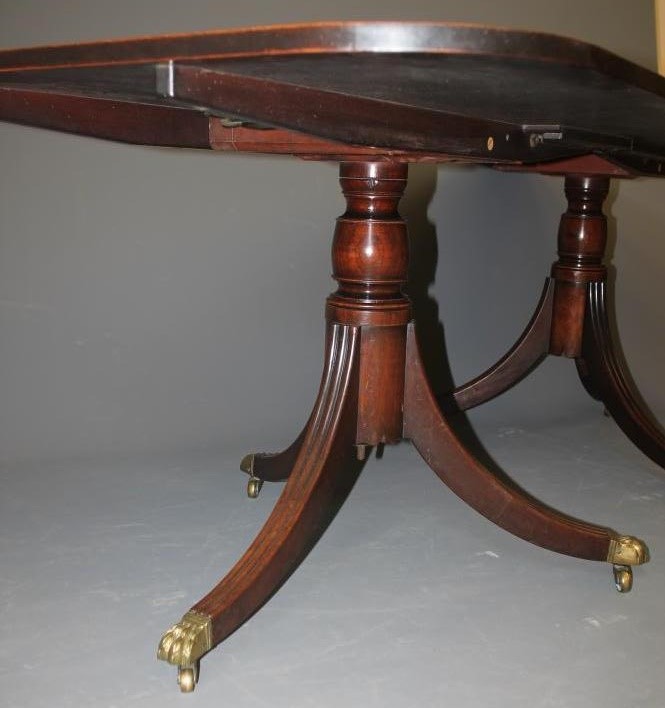 A MAHOGANY TWIN PILLAR EXTENDING DINING TABLE of Georgian design Image