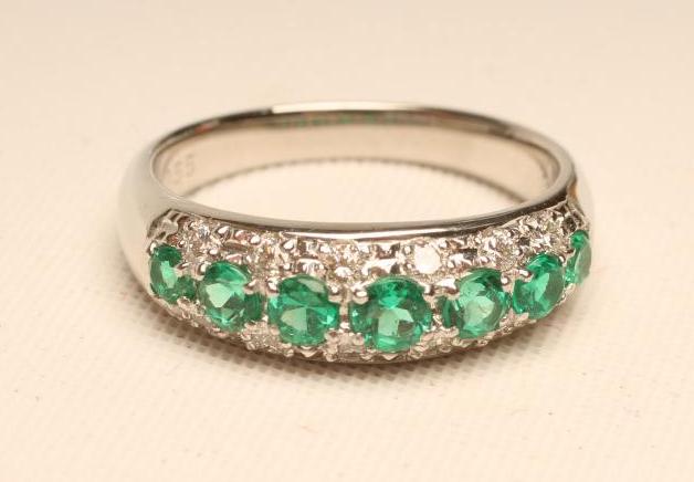 AN EMERALD AND DIAMOND HALF HOOP RING Image