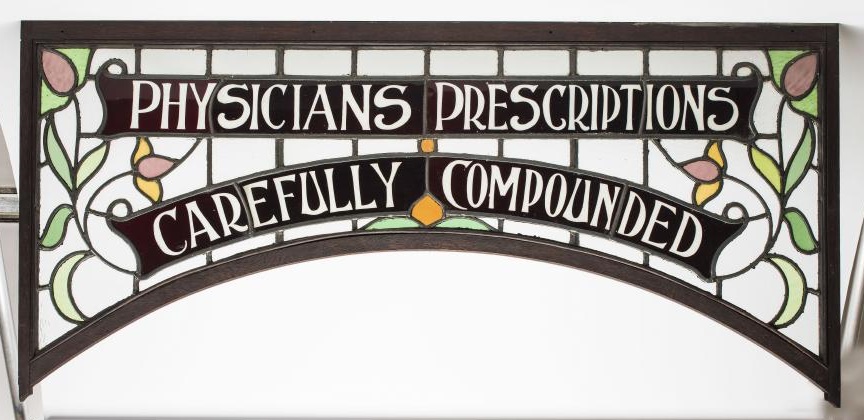 THREE VARIOUS PHARMACIST'S STAINED GLASS ADVERTISING PANELS each of oblong form with arched lower Image