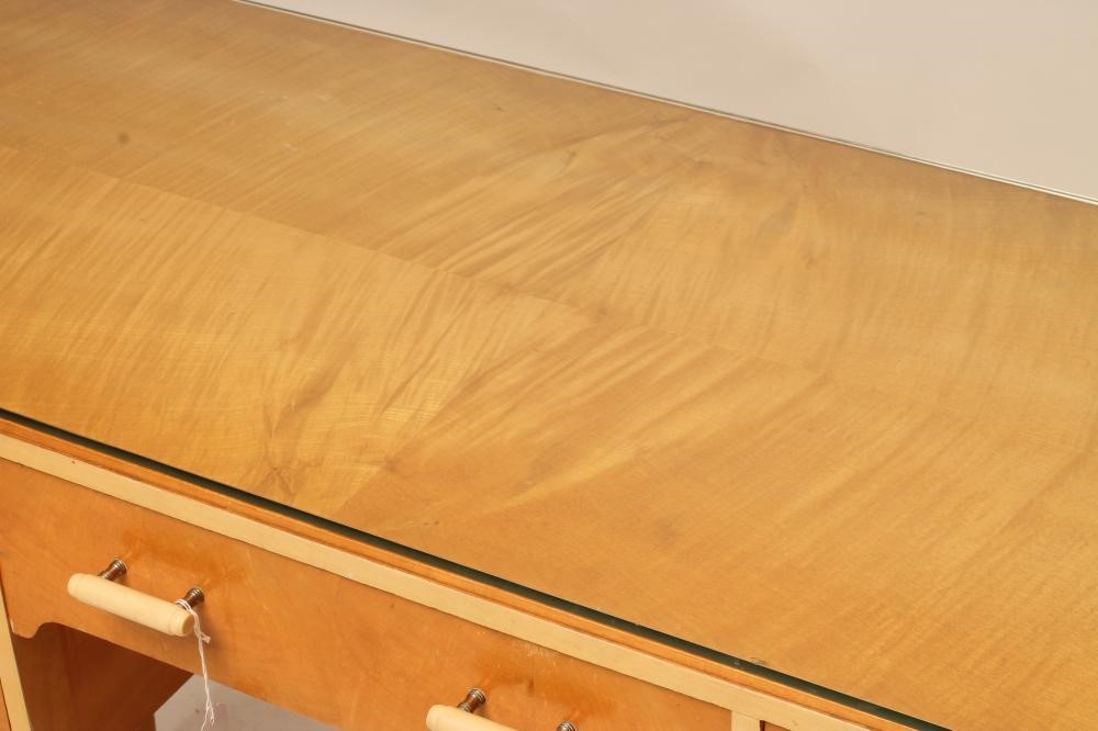 AN ART DECO SATIN BIRCH AND PAINTED SIDE TABLE of rounded oblong kneehole form Image