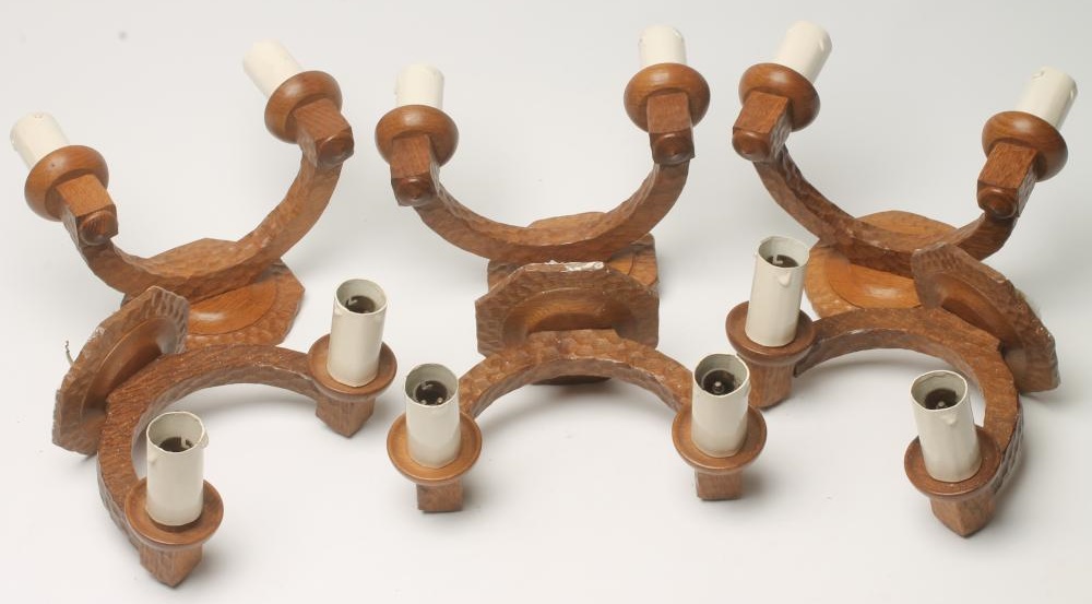 A SET OF SIX ADZED OAK WALL LIGHTS each crescent shaped support issuing a pair of sconces with faux Image