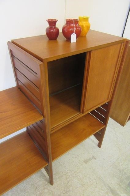 A STAPLES LADDERAX TEAK ROOM UNIT comprising two cupboard units with sliding doors and eight shelves Image