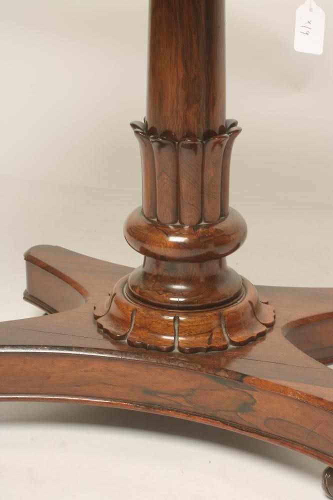 A REGENCY ROSEWOOD FOLDING CARD TABLE of rounded oblong form lined with red baize Image
