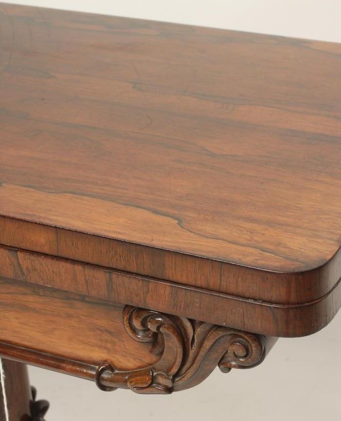 A REGENCY ROSEWOOD FOLDING CARD TABLE of rounded oblong form lined with red baize Image