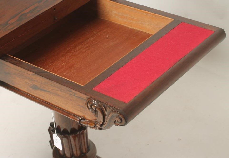A REGENCY ROSEWOOD FOLDING CARD TABLE of rounded oblong form lined with red baize Image