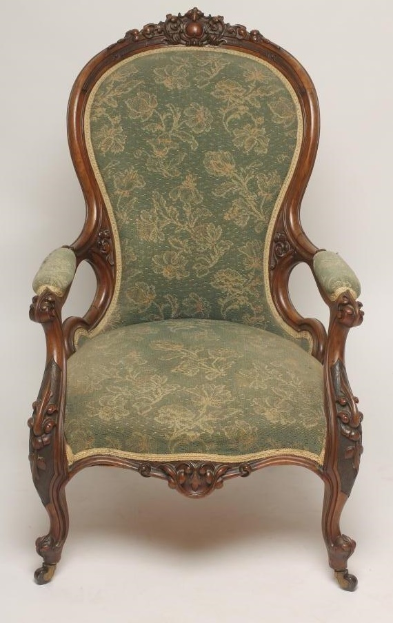 A VICTORIAN WALNUT FRAMED ARMCHAIR of spoonback form upholstered in green cut moquette Image
