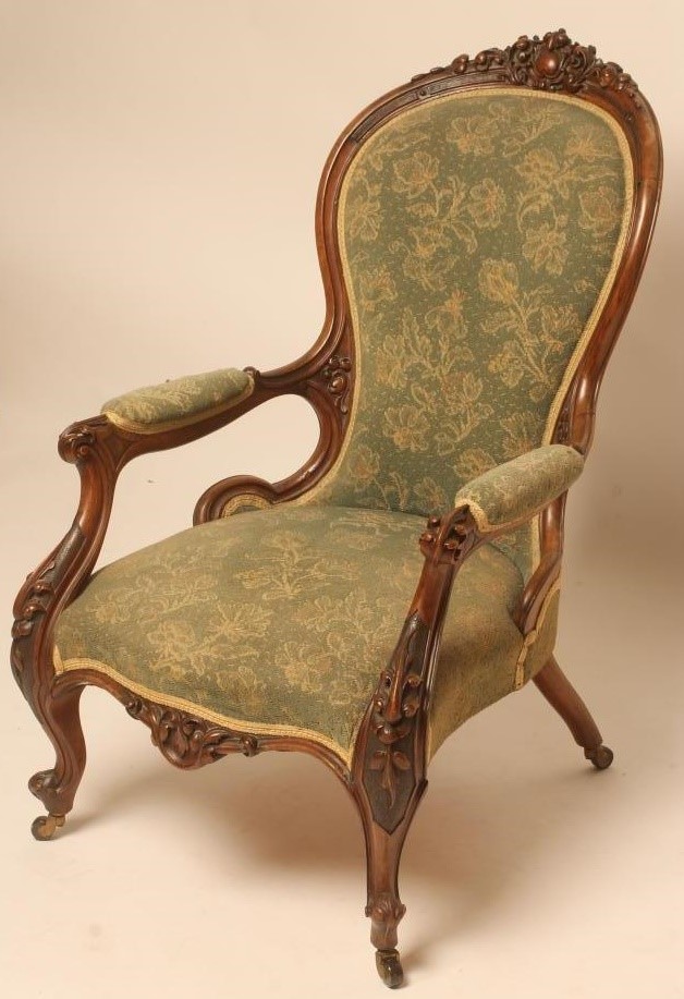 A VICTORIAN WALNUT FRAMED ARMCHAIR of spoonback form upholstered in green cut moquette Image