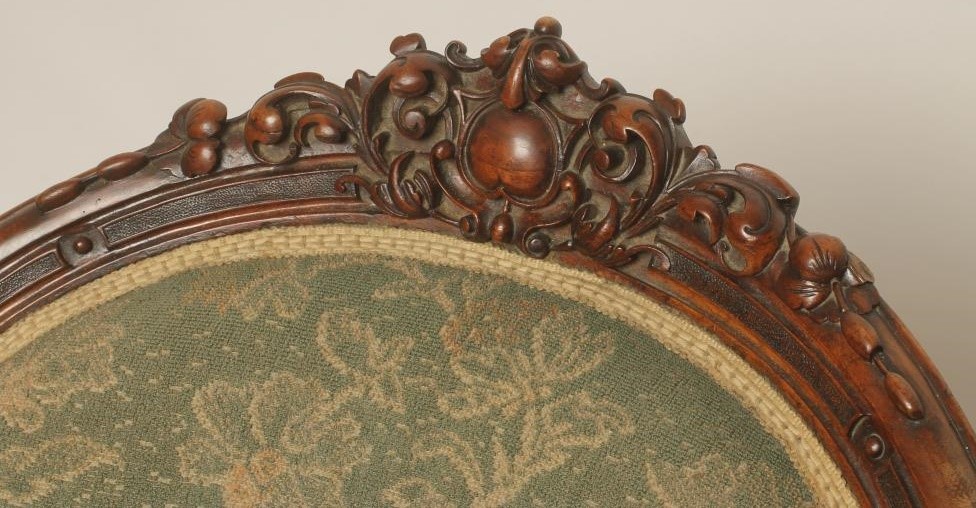 A VICTORIAN WALNUT FRAMED ARMCHAIR of spoonback form upholstered in green cut moquette Image