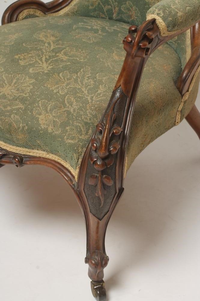 A VICTORIAN WALNUT FRAMED ARMCHAIR of spoonback form upholstered in green cut moquette Image