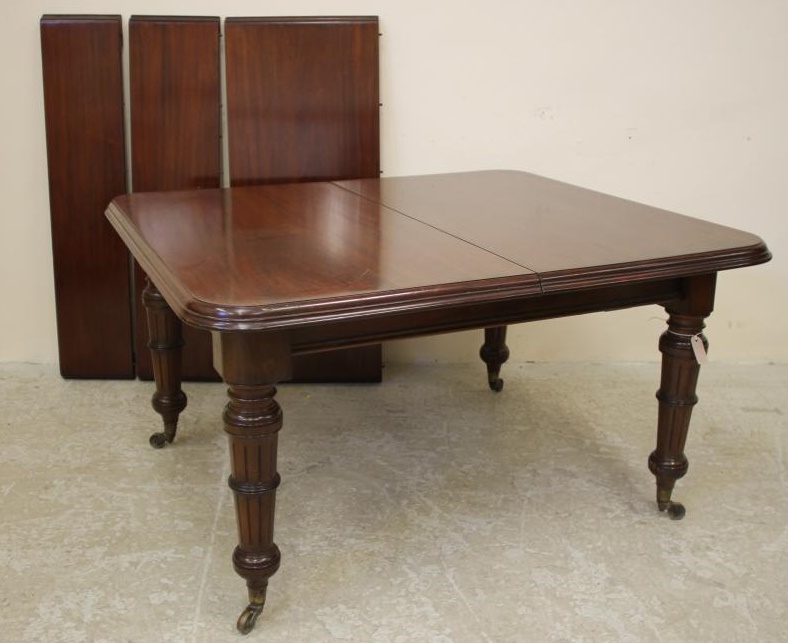A VICTORIAN MAHOGANY EXTENDING DINING TABLE of rounded oblong form with three leaves and wind out Image