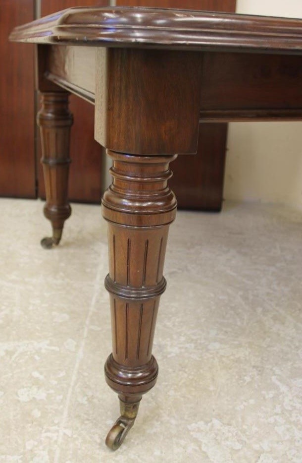 A VICTORIAN MAHOGANY EXTENDING DINING TABLE of rounded oblong form with three leaves and wind out Image