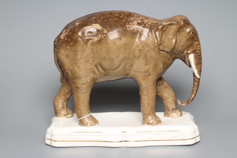 A STAFFORDSHIRE POTTERY MODEL OF JUMBO, the elephant standing on a gilt lined shaped oblong base, 11 Image