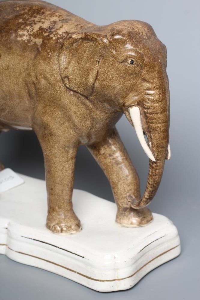 A STAFFORDSHIRE POTTERY MODEL OF JUMBO, the elephant standing on a gilt lined shaped oblong base, 11 Image