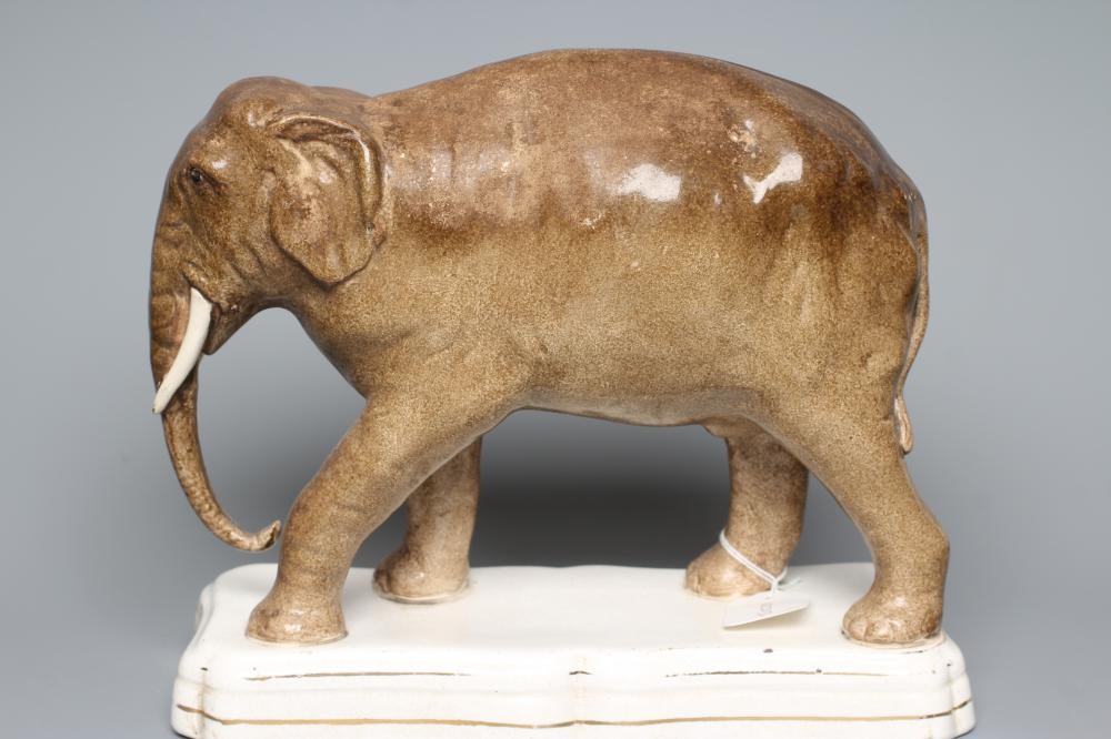 A STAFFORDSHIRE POTTERY MODEL OF JUMBO, the elephant standing on a gilt lined shaped oblong base, 11 Image