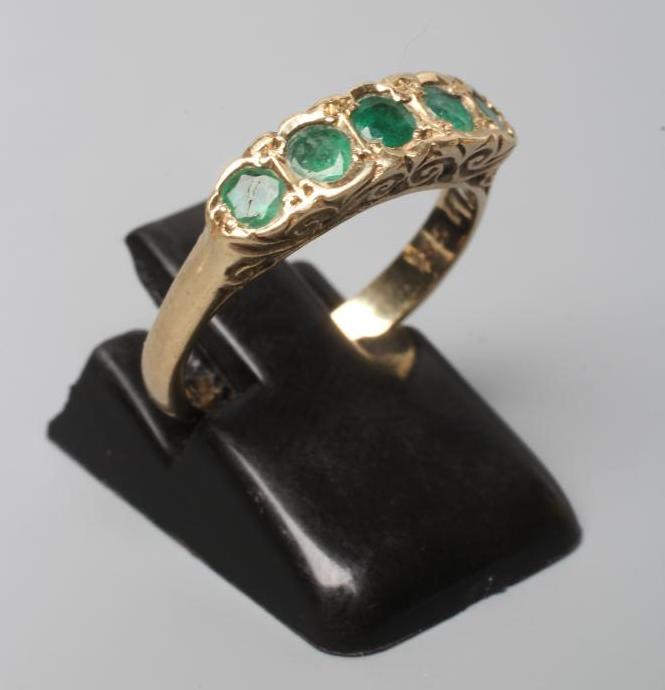 A FIVE STONE EMERALD HALF HOOP RING, the oval facet cut stones collet set to a plain 9ct gold shank, Image