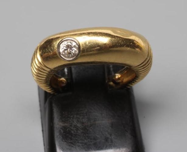 AN UNUSUAL DIAMOND RING, the plain wide panel offset with a collet set with a round brilliant cut Image