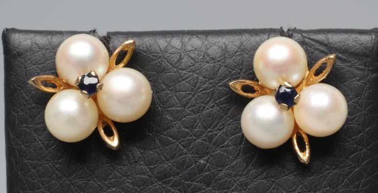 A PAIR OF CULTURED PEARL EAR STUDS, the three pearls peg set and centred by a small sapphire with Image