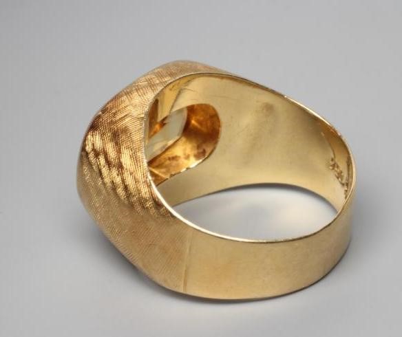 A GENTLEMAN'S DRESS RING, the oval facet cut citrine collet set to criss-cross engraved shoulders Image