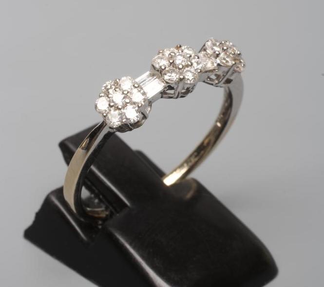 A DIAMOND TRIPLE CLUSTER RING, the seven stone small clusters with two pairs of baguette cut stones Image