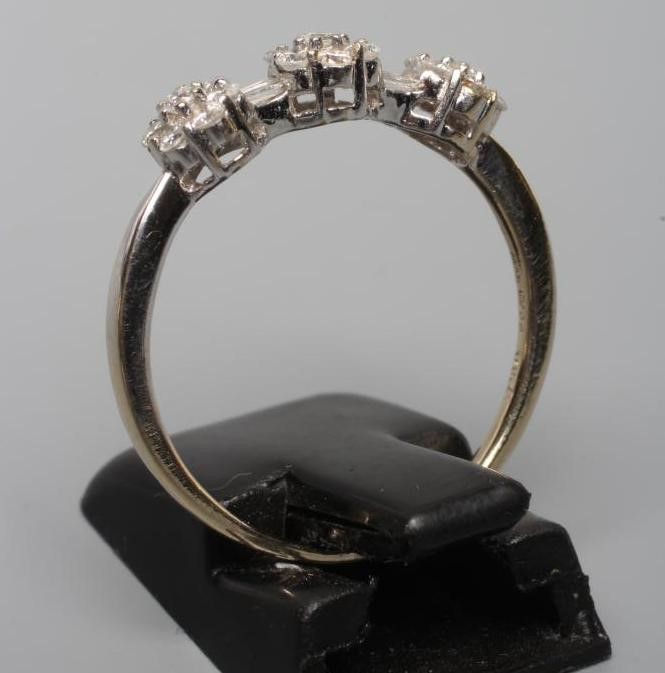 A DIAMOND TRIPLE CLUSTER RING, the seven stone small clusters with two pairs of baguette cut stones Image