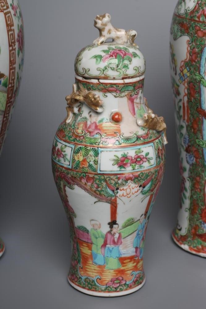 THREE CANTONESE PORCELAIN FAMILLE ROSE VASES AND COVERS of inverted baluster form, all painted with Image