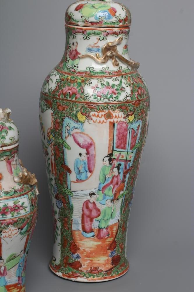 THREE CANTONESE PORCELAIN FAMILLE ROSE VASES AND COVERS of inverted baluster form, all painted with Image