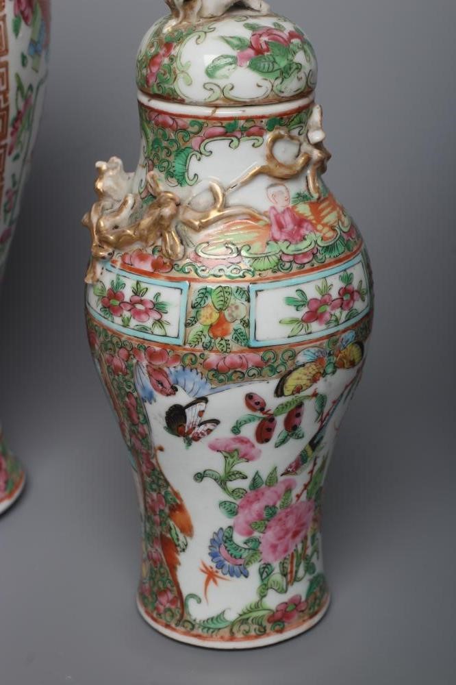 THREE CANTONESE PORCELAIN FAMILLE ROSE VASES AND COVERS of inverted baluster form, all painted with Image