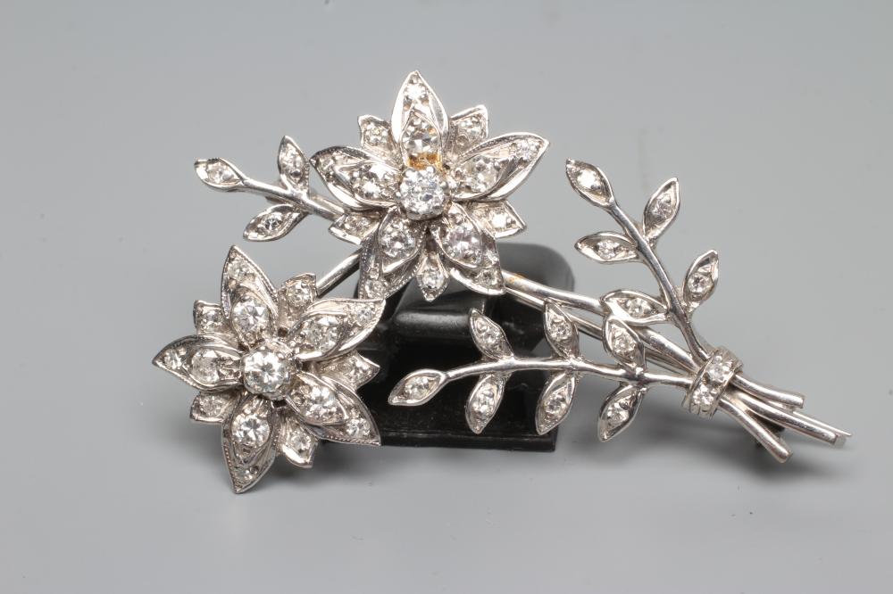 A DIAMOND FLOWER SPRAY BROOCH, the two flowerhead clusters with three leafy branches to an unmarked Image