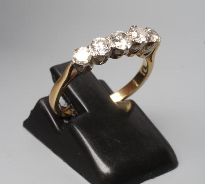 A FIVE STONE DIAMOND RING, the round brilliant cut stones point set to a plain 14ct gold shank, Image