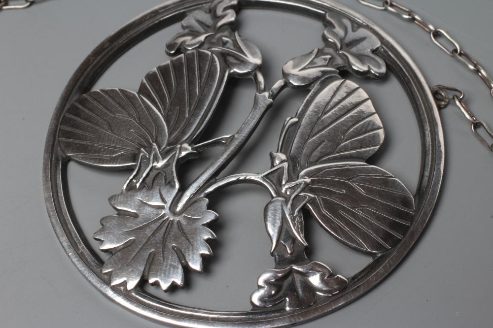 A GEORG JENSEN SILVER CIRCULAR PENDANT to match the previous lot, fixed to a fine chain necklace, Image