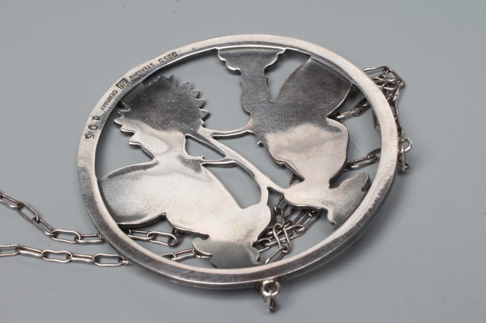 A GEORG JENSEN SILVER CIRCULAR PENDANT to match the previous lot, fixed to a fine chain necklace, Image