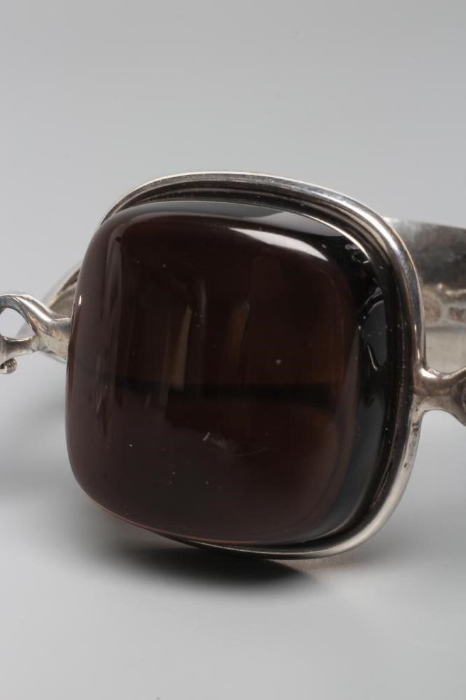 A GEORG JENSEN SILVER BANGLE designed by Vivianna Torun Bulow-Hube, the tension clamp centred by a Image