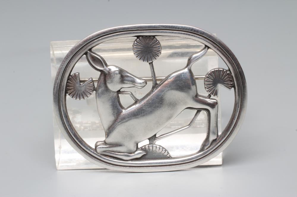 A GEORG JENSEN SILVER OVAL BROOCH designed by Arno Malinowski, cast as a kneeling deer, stamped and Image