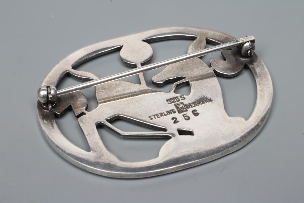 A GEORG JENSEN SILVER OVAL BROOCH designed by Arno Malinowski, cast as a kneeling deer, stamped and Image