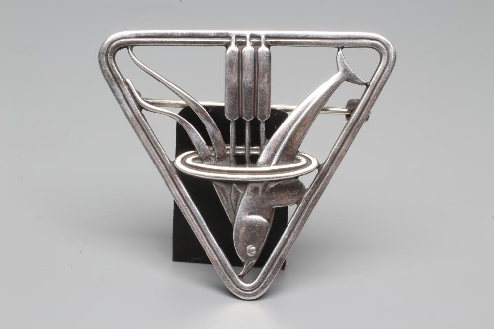 A GEORG JENSEN SILVER TRIANGULAR BROOCH designed by Arno Malinowski, cast as a dolphin and reeds, Image