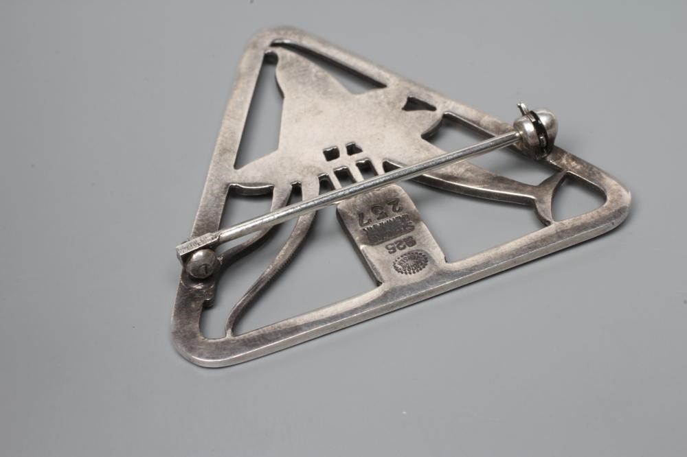 A GEORG JENSEN SILVER TRIANGULAR BROOCH designed by Arno Malinowski, cast as a dolphin and reeds, Image