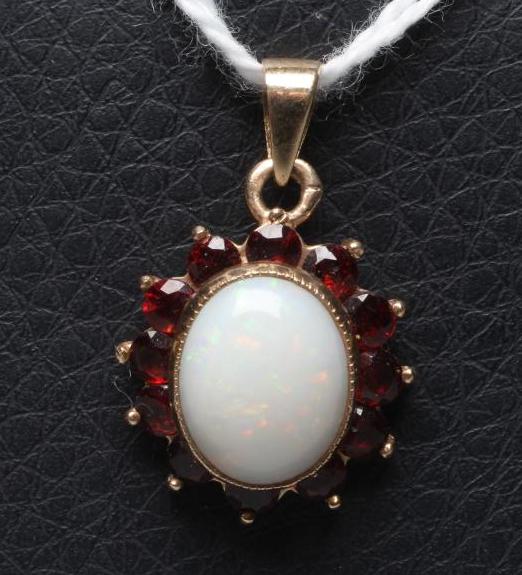 AN OPAL AND GARNET CLUSTER PENDANT, the oval cabochon polished opal collet set to a border of small Image