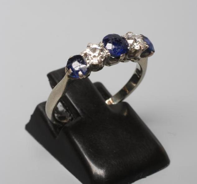 A FIVE STONE SAPPHIRE AND DIAMOND HALF HOOP RING, the three sapphires and two round brilliants claw Image
