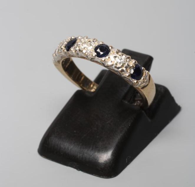 A SAPPHIRE AND DIAMOND HALF HOOP RING, the four sapphires and three illusion set diamonds to a plain Image
