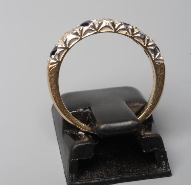 A SAPPHIRE AND DIAMOND HALF HOOP RING, the four sapphires and three illusion set diamonds to a plain Image