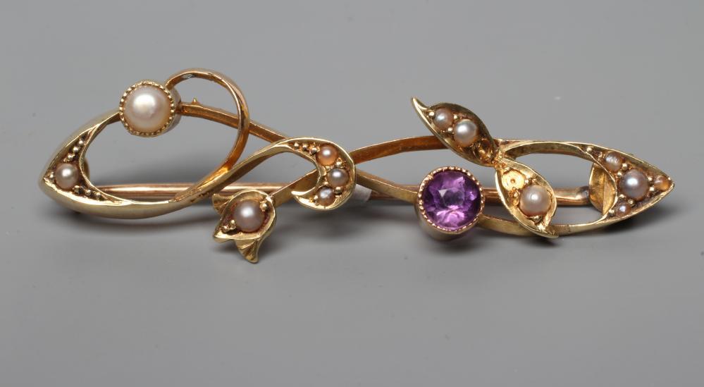 AN ART NOUVEAU BROOCH, the open scrolls set with seed pearls and an open back collet set amethyst, Image