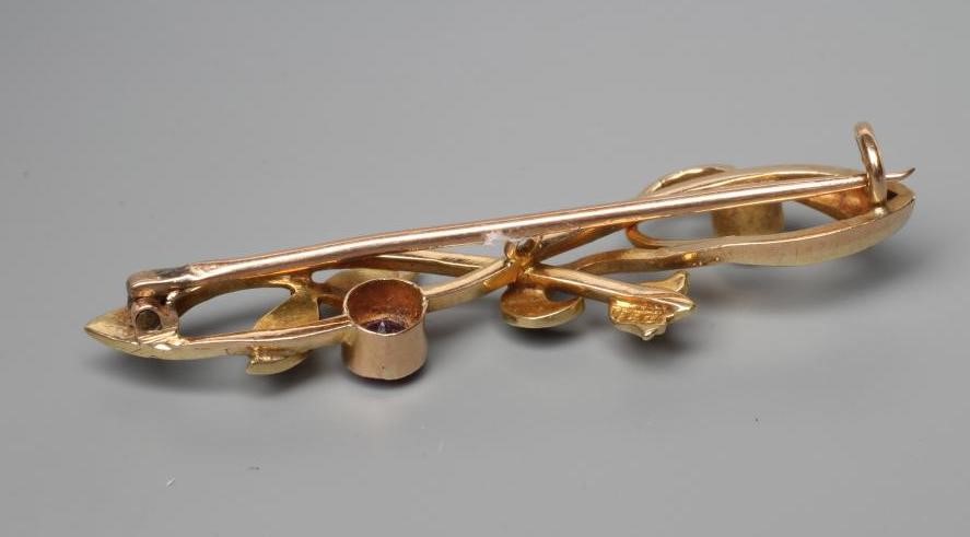 AN ART NOUVEAU BROOCH, the open scrolls set with seed pearls and an open back collet set amethyst, Image