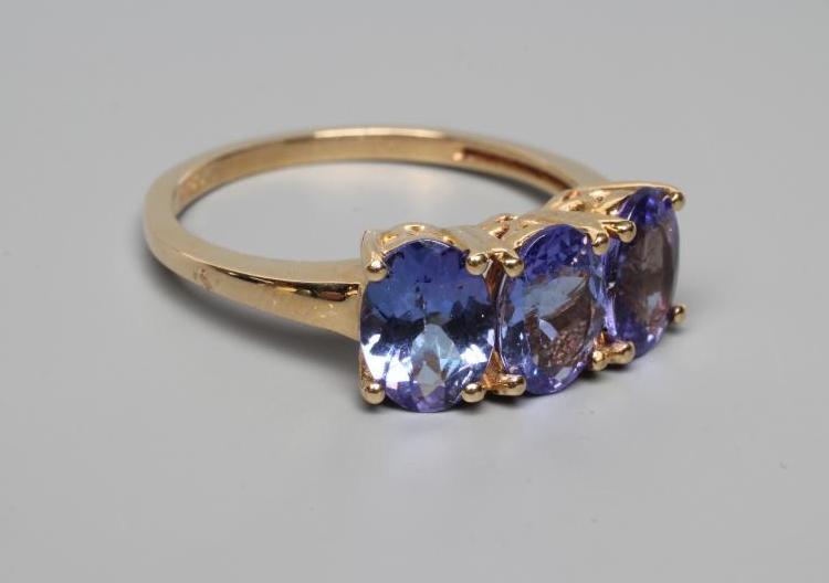 A THREE STONE TANZANITE RING, the oval facet cut stones claw set to a plain shank, stamped 14k, 585, Image