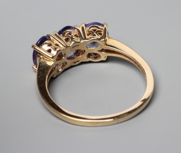 A THREE STONE TANZANITE RING, the oval facet cut stones claw set to a plain shank, stamped 14k, 585, Image