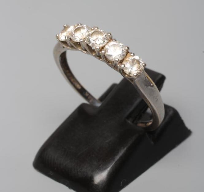 A FIVE STONE DIAMOND RING, the round brilliant cut stones point set to a plain white shank, stamped Image