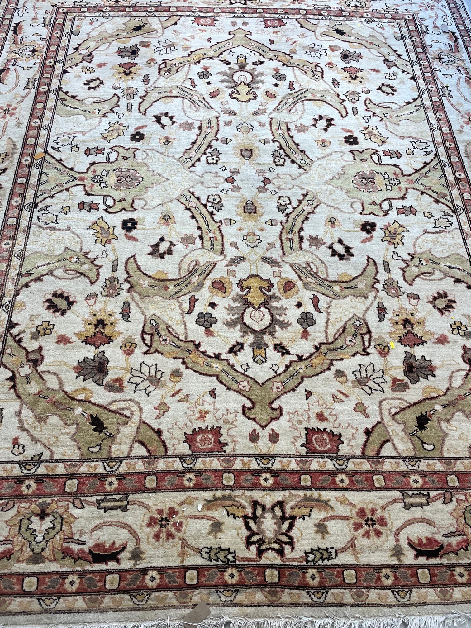 A persian style wool carpet, the ivory ground with all over bold