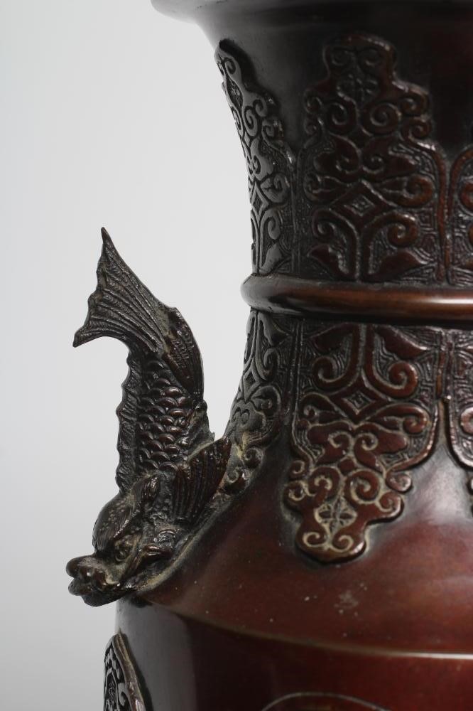 A JAPANESE BRONZE VASE of cylindrical form with two dolphin handles, cast in relief with wading Image